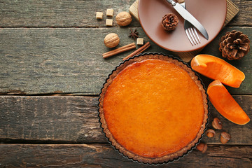 Pumpkin tart with plate, fork and knife on wooden table