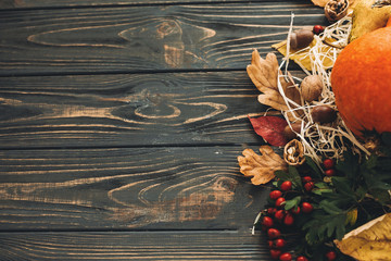 Pumpkin, autumn vegetables with colorful leaves,acorns,nuts, berries on wooden rustic table, flat lay with space for text. Fall seasons greeting card. Happy Thanksgiving. Hello Autumn
