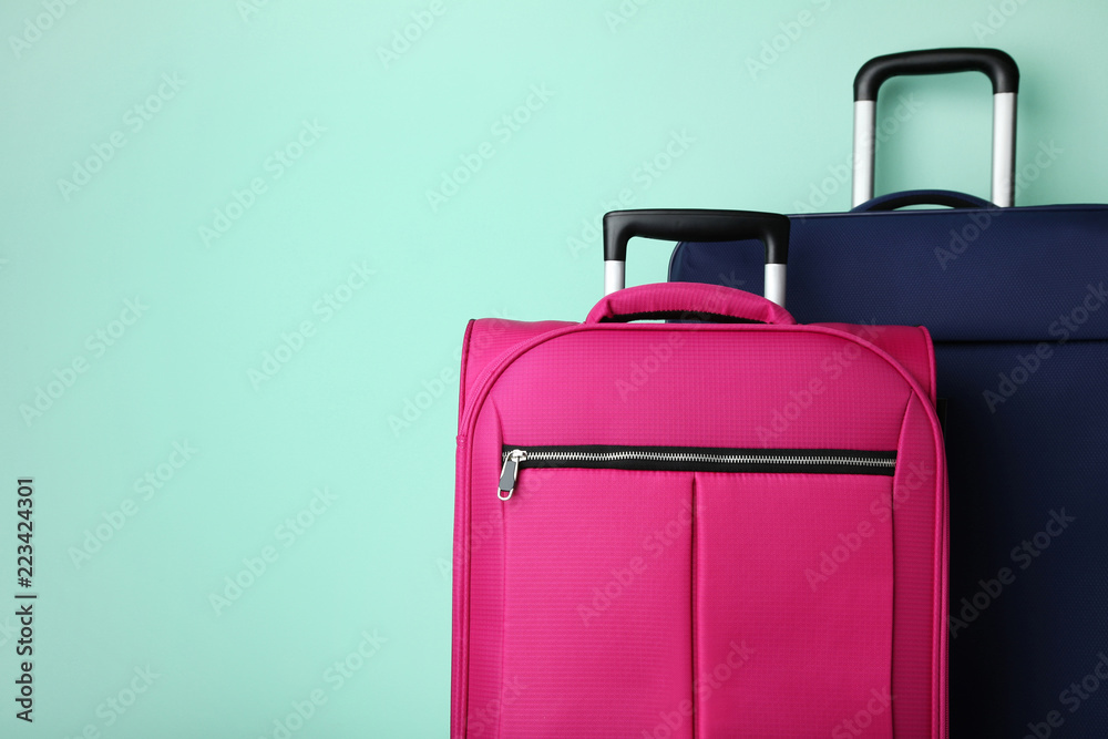 Wall mural blue and pink suitcases on mint background