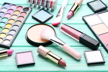 Obraz na płótnie Canvas Different makeup cosmetics on mint wooden table
