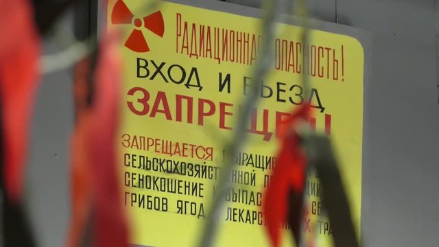 Radiation danger! Pass and drive is prohibited. It is forbidden to grow and collect agricultural products. Yellow plate with an inscription of radiation hazard. Radiation hazard sign.