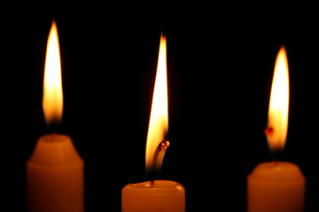 Burning candles on black background