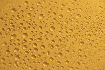 Fototapeta na wymiar natural water drops on yellow golden background texture