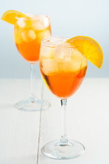 Aperol Spritz served with an orange slice in wine glasses. White background, high resolution