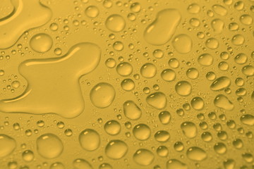 natural water drops on yellow golden background texture