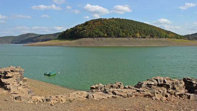 Der ausgetrocknete Edersee voller Blaualgen mit der aufgetauchten Bericher Hütte und dem Sperrmauermodell
