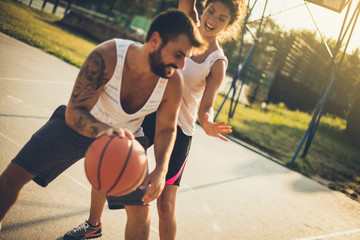 Young couple playing basketball. Moving activity.