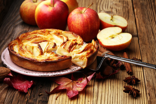Apple tart. Gourmet traditional holiday apple pie sweet baked dessert food with cinnamon and apples on vintage background. Autumn decor. Rustic style.