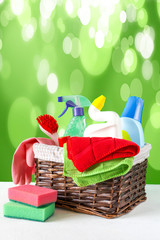basket with a set of accessories for cleaning cleaning agents and rags and gloves. Empty space for text or logo on a blue background. The concept of cleaning service. Spring background