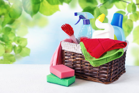 basket with a set of accessories for cleaning cleaning agents and rags and gloves. Empty space for text or logo on a blue background. The concept of cleaning service. Spring background