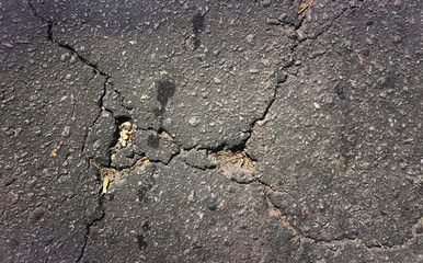 Broken asphalt road texture. Damaged highway closeup.