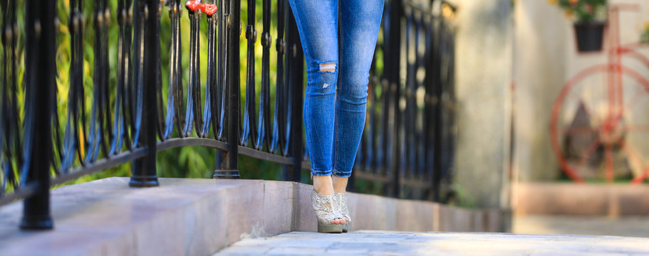 beautiful legs of a girl in blue jeans outdoors