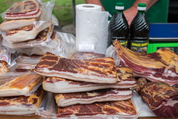 bacon for sale at outdoor farmers market.