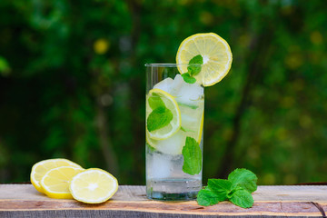 A glass of lemonade with lemon and mint