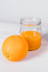 Fototapeta na wymiar Glass jar with freshly squeezed orange juice