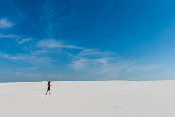 Mysterious girl walk far with aquarium in desert
