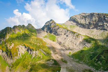 Green mountain covered with grass on the blue sky background.