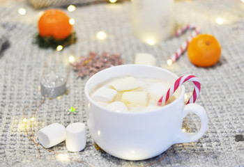 big cup of festive hot cocoa with marshmallows and candy canes
