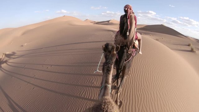 POV, riding camels in scenic desert