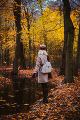 Woman enjoying the silence on the shore of autumn lake. Woman and autumn composition