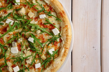 Half of pizza with blue cheese, masdam, feta, cheddar and arugula