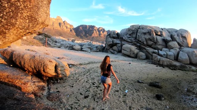 POV, woman walks on sunset beach in Cape Town