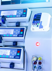 rows of panels of modern medical equipment, blurring depth of field, monitors and keys close-up, blue toning