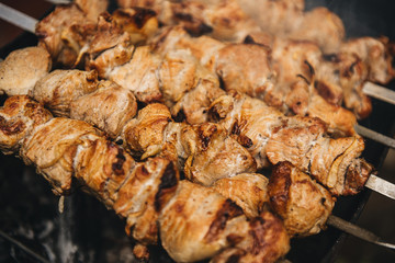 Appetizing shish kebab roasted on skewers on open air charcoal grill. Shish kebab with smoke