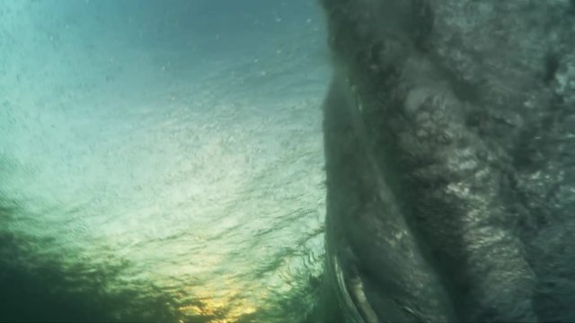 Surfer passes on wave, underwater POV