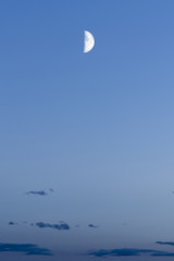 Fototapeta premium half moon against the background of the night blue sky with dark clouds, abstract background