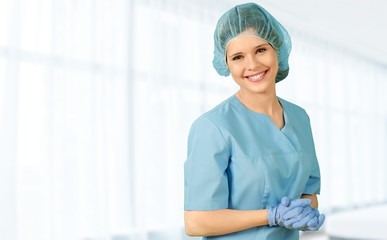 Attractive young female doctor with blurred hospital