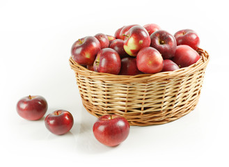 Wiklinowy kosz pełen czerwonych jabłek