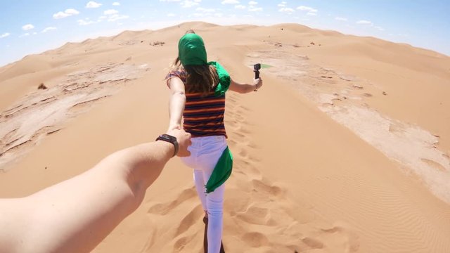 Holding hands in vast desert landscape, POV
