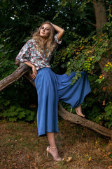 girl in blue clothes leaning on a branch of a tree © Анна Антонова