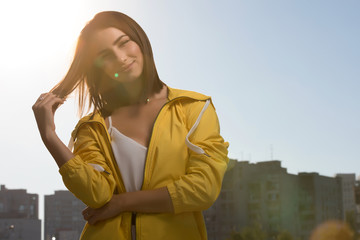 Pretty woman outdoor portrait at sky background in yellow windbreaker © antgor