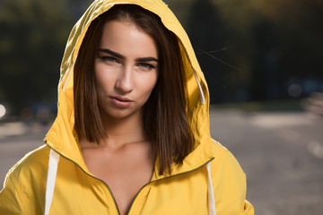 Confident serious woman outdoor portrait under yellow hood © antgor