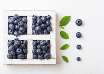 Fresh raw organic blueberries with leaf in vintage wooden box on stone kitchen background. Top view. Food concept