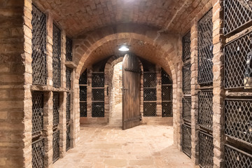 Fototapeta na wymiar Old wine cellar with wine storage cases and open vintage wooden doors.