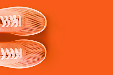 Bright orange sneakers on an orange background.