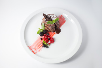 Chocolate fondant with berries and mint on the white plate