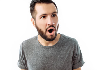 Portrait of cheerful and very surprised man with beard, in grey t-shirt looking at camera isolated on white background