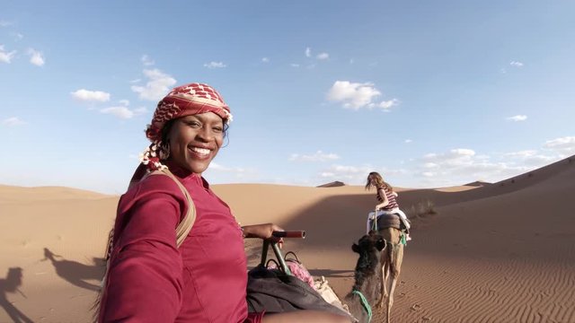 Riding camel in vast desert landscape, POV