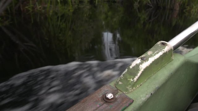 Close Up of boat railing on water driving through the jungle of borneo