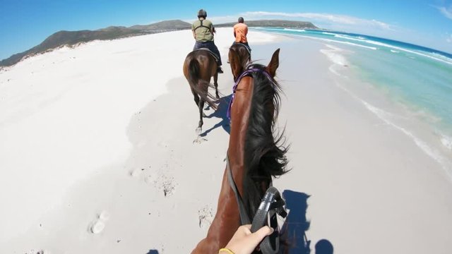 POV, horseback riders on beach