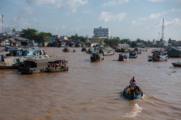 Fototapeta premium Tourists, people buy and sell food, vegetable, fruits on vessel, boat, ship in Cai Rang floating market, Mekong River. Royalty stock image of traffic on the floating market or river market in Vienam