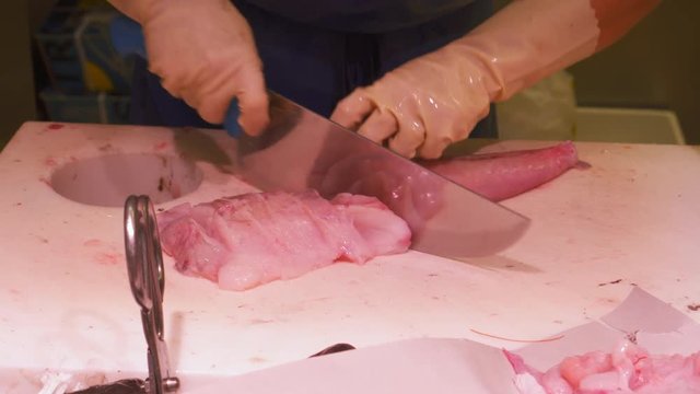 Fish vendor cutting into slices fresh sea fish