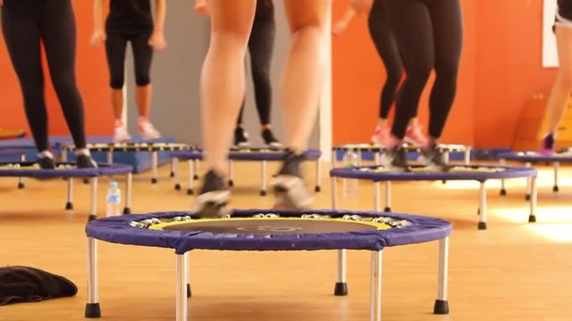 Girls legs jumping on fitness trampoline rebounder.