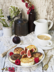 Cottage cheese pancakes with fresh figs and honey and cup of coffee for breakfast.