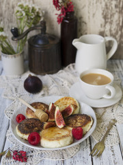 Cottage cheese pancakes with fresh figs and honey and cup of coffee for breakfast.