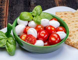 Italian soft cheese, young small balls mozzeralla cheese salad served with fresh basil and tasty ripe cherry tomatoes